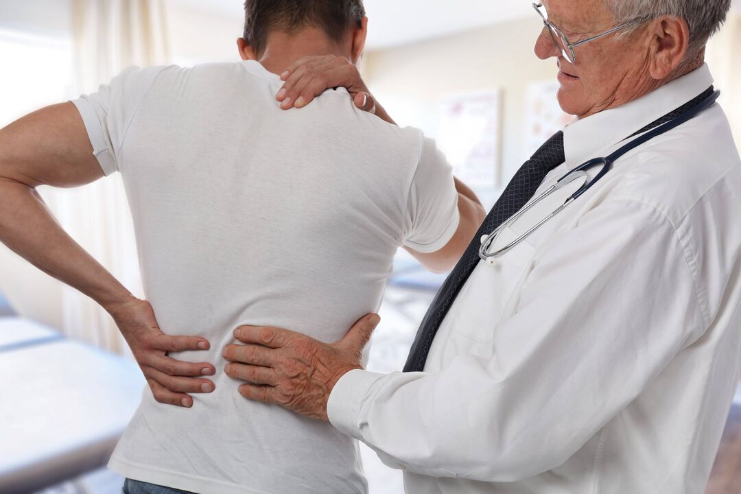 лекар кој прегледува пациент со болки во грбот
